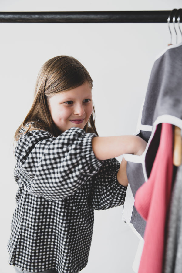Girl smiling and using The Hanger Valet to organizer her outfit